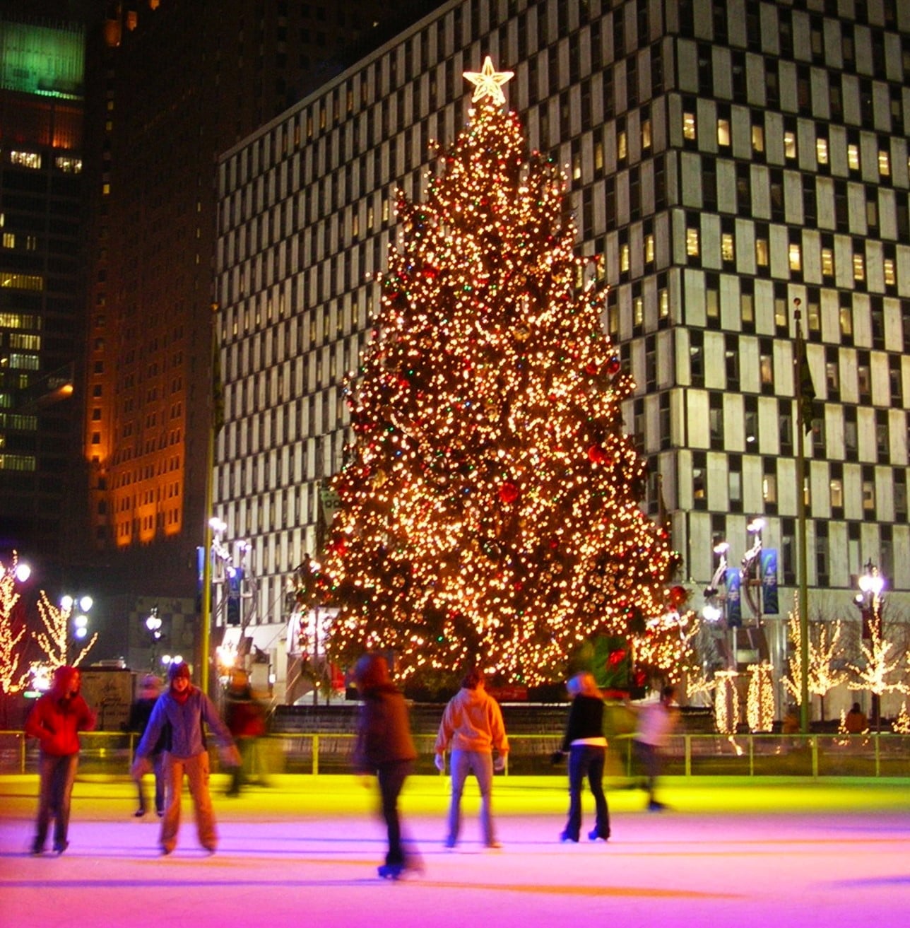 Skaters enjoy the rink at popular Campus Martius Park in Downtown Detroit. The glowing holiday tree is lit up in the background.